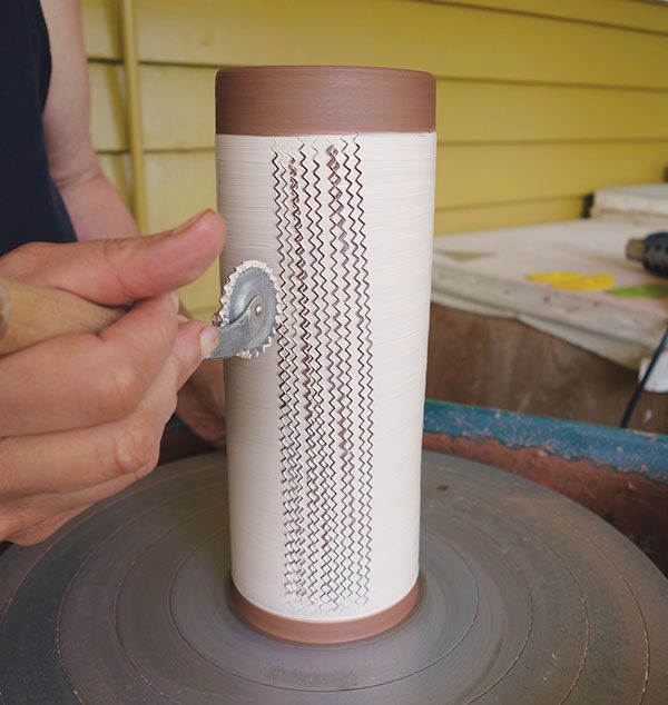 1 With the wheel stopped, roll the fluted pastry wheel vertically up the cylinder in repeated rows.