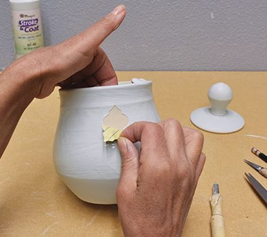 5 Peel the paper stencils off of the freshly glazed pot before the glaze hardens.